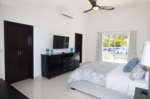 bedroom with TV, dresser, and balcony in penthouse condo at The SANCTUARY at Los Corales